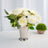 Artificial white peony arrangement in a silver vase.