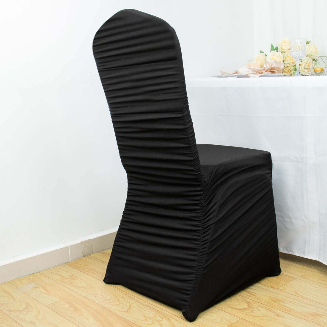 Black chair cover with pleated design, perfect for elegant events.