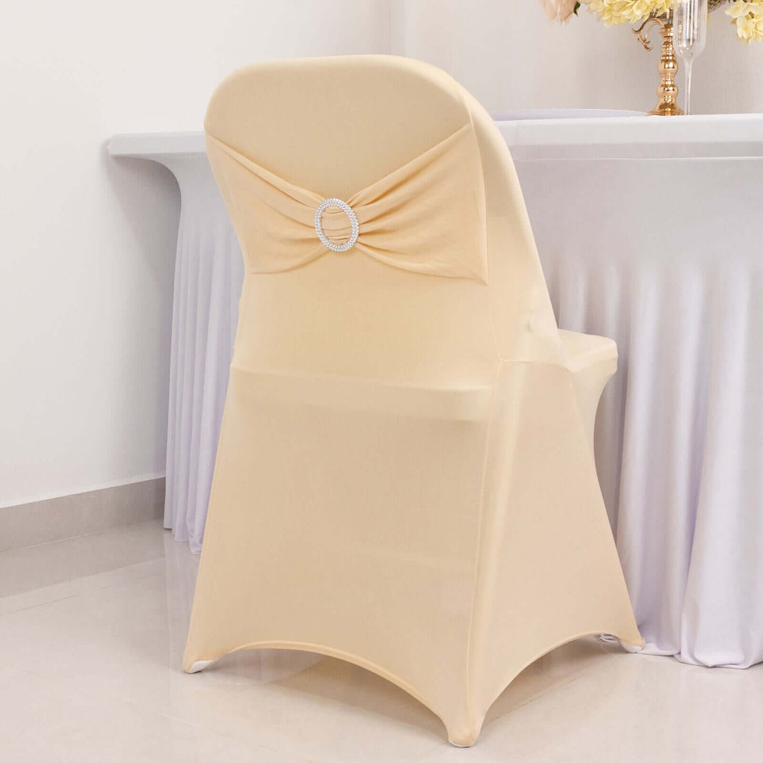 Elegant beige chair cover with decorative back detail.
