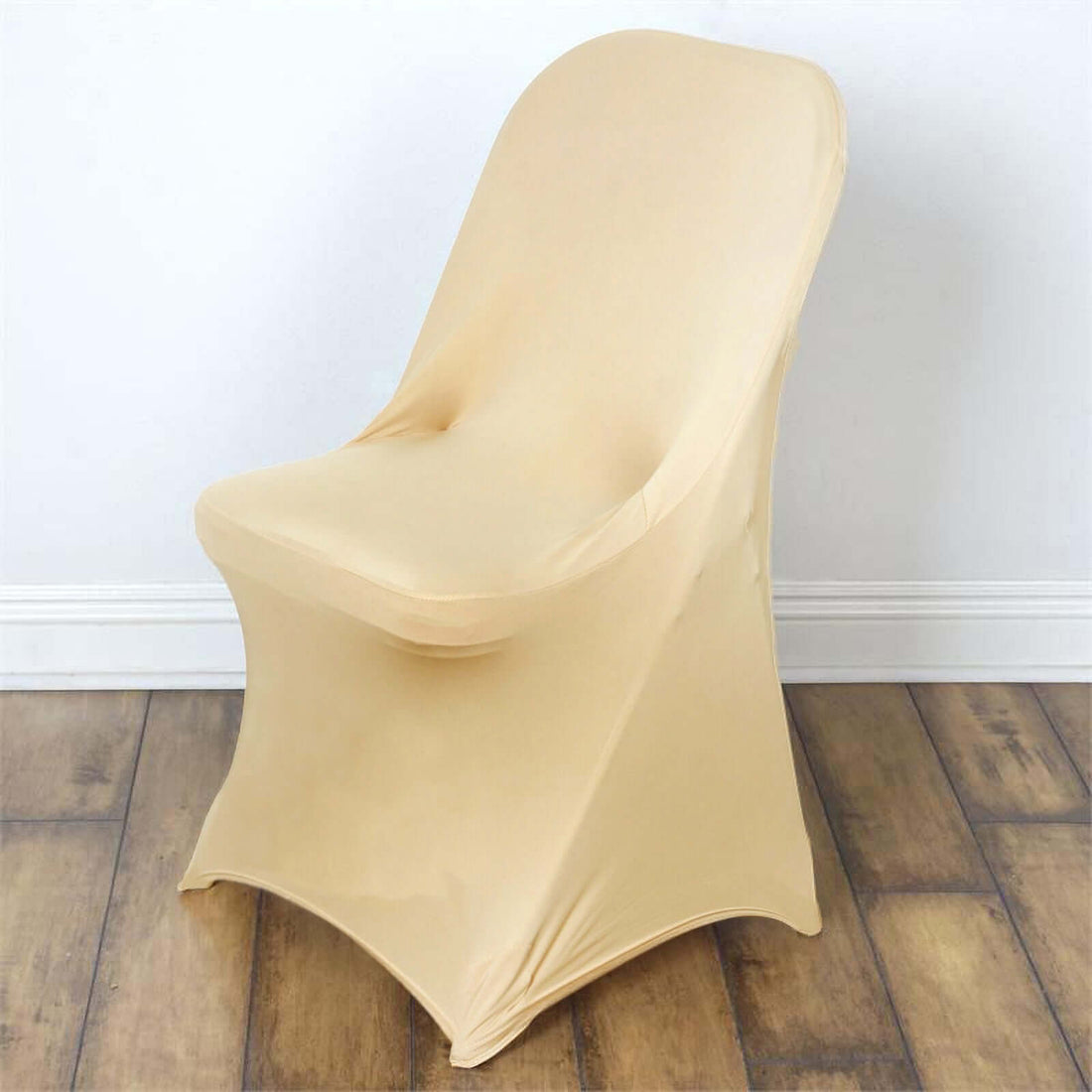 Beige stretch chair cover on a wooden floor.