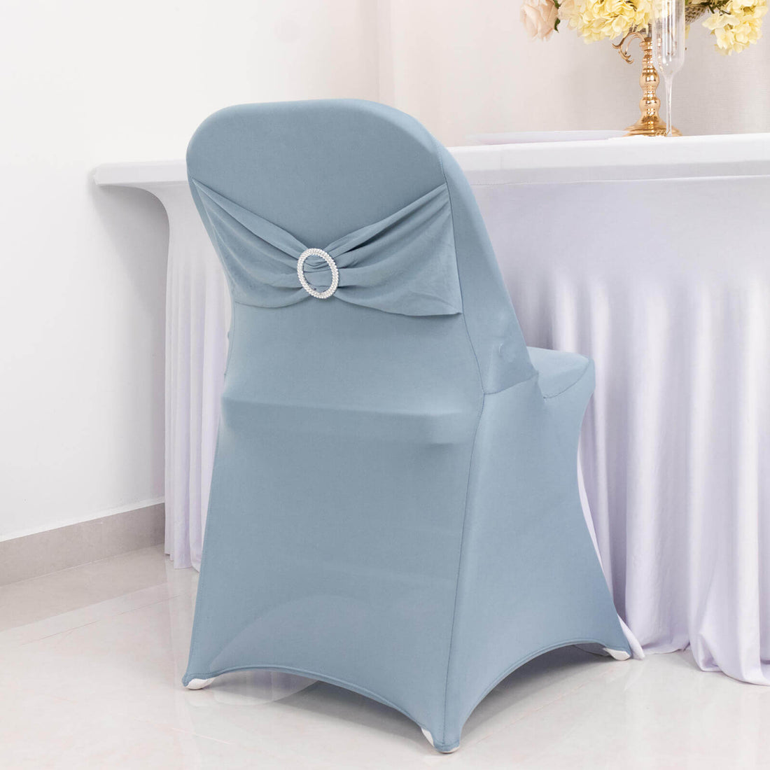 Elegant blue chair cover with a decorative ring detail.