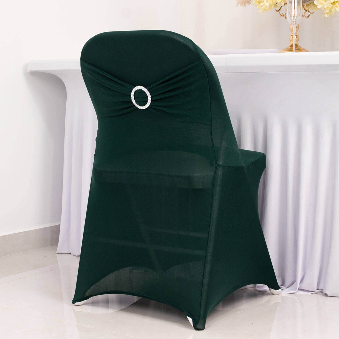 Elegant dark green chair cover with decorative buckle detail.