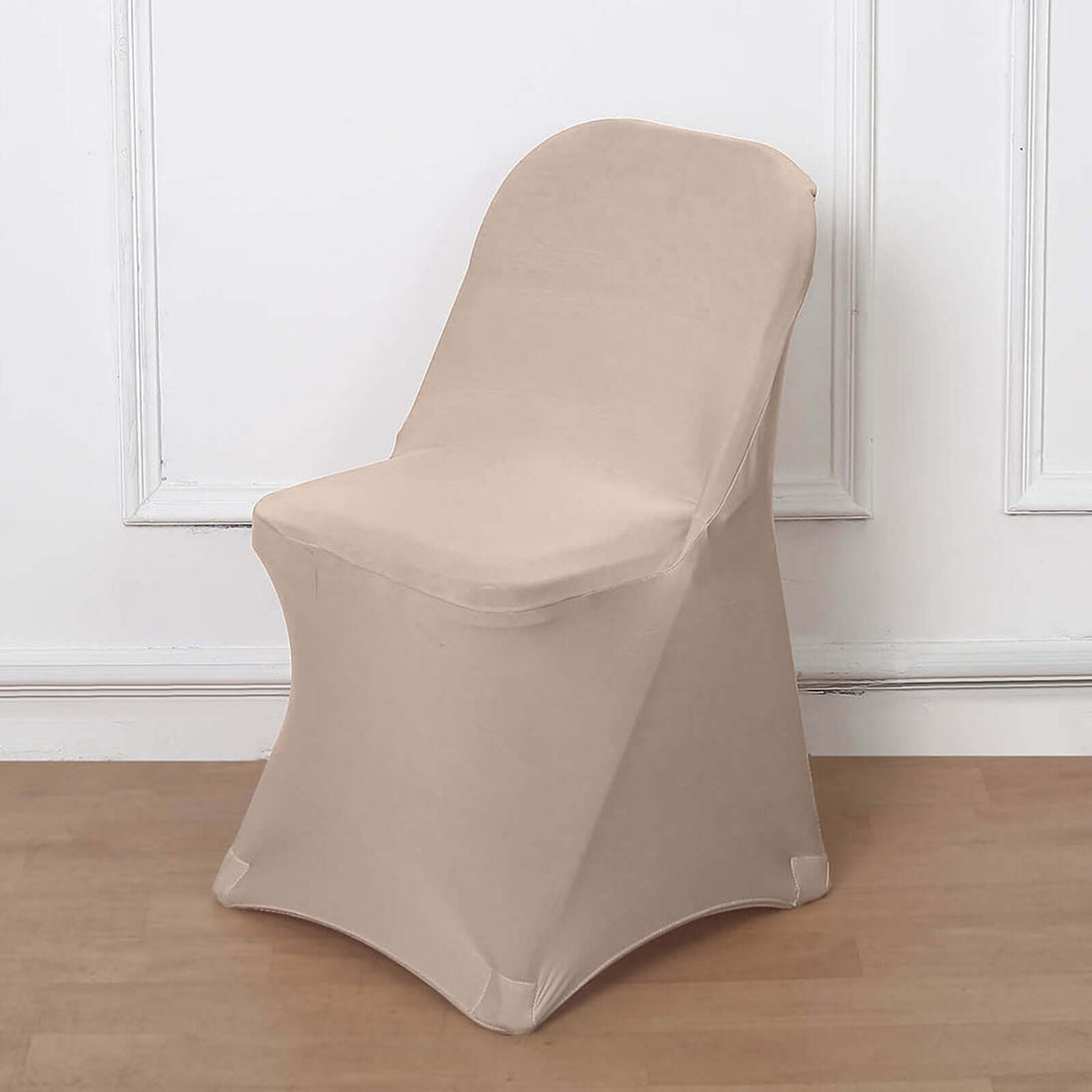 Beige chair cover draped over a chair on a plain backdrop.