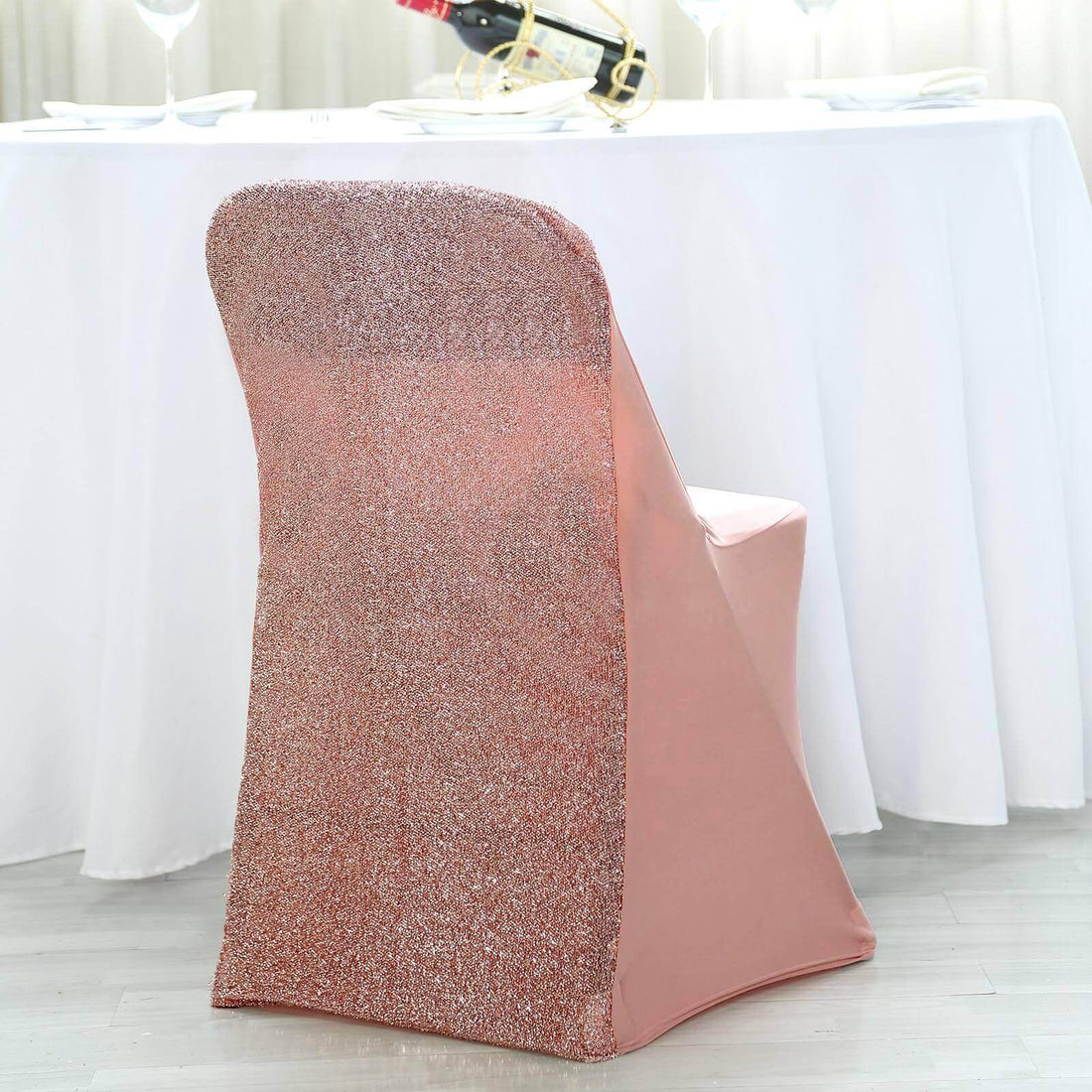 Rose gold sequined chair cover on a dining chair at a festive table setting.