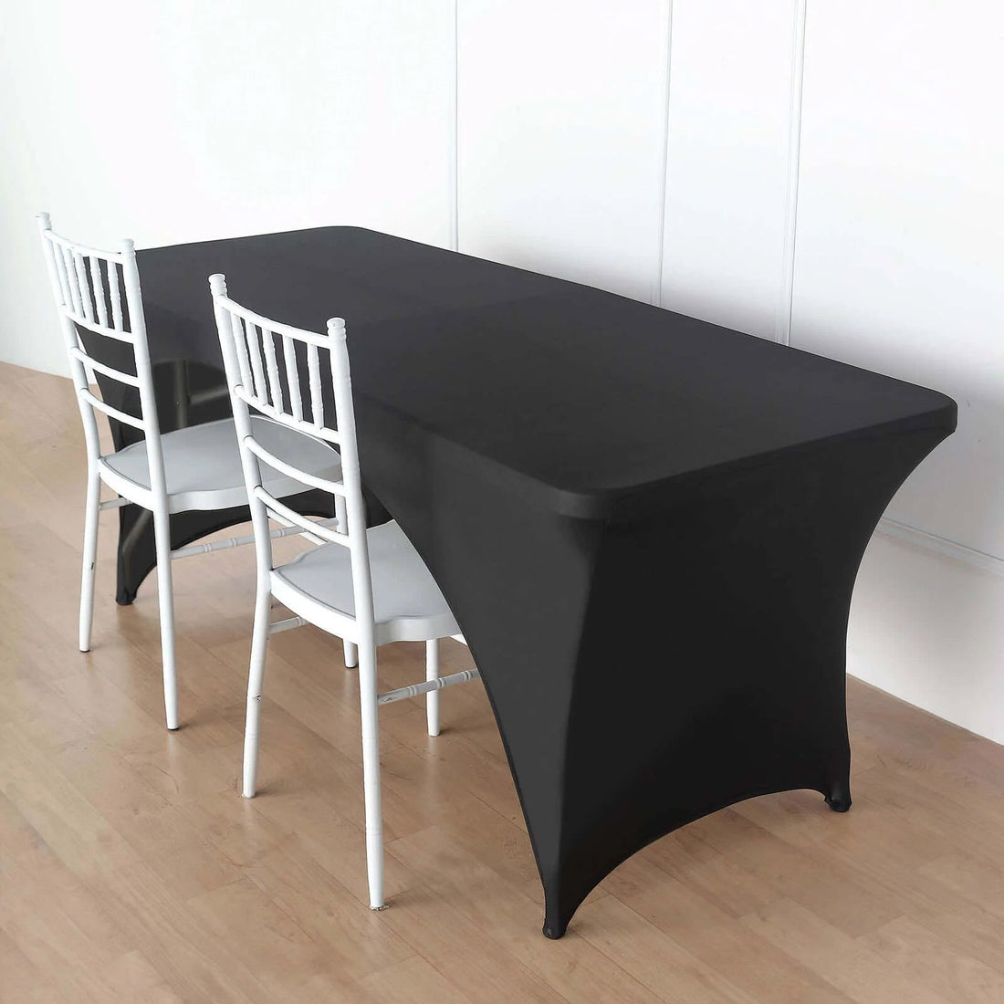 Black fitted table cover on a rectangular table with white chairs