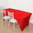 Red table cover draped over a table with white chairs in a plain setting.