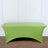 Green fitted table cover on a plain surface.