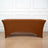Brown stretch table cover on a wooden floor with a white backdrop.