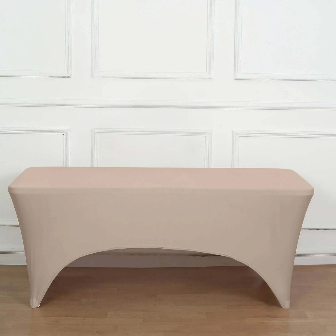 Beige stretch table cover on a plain backdrop.
