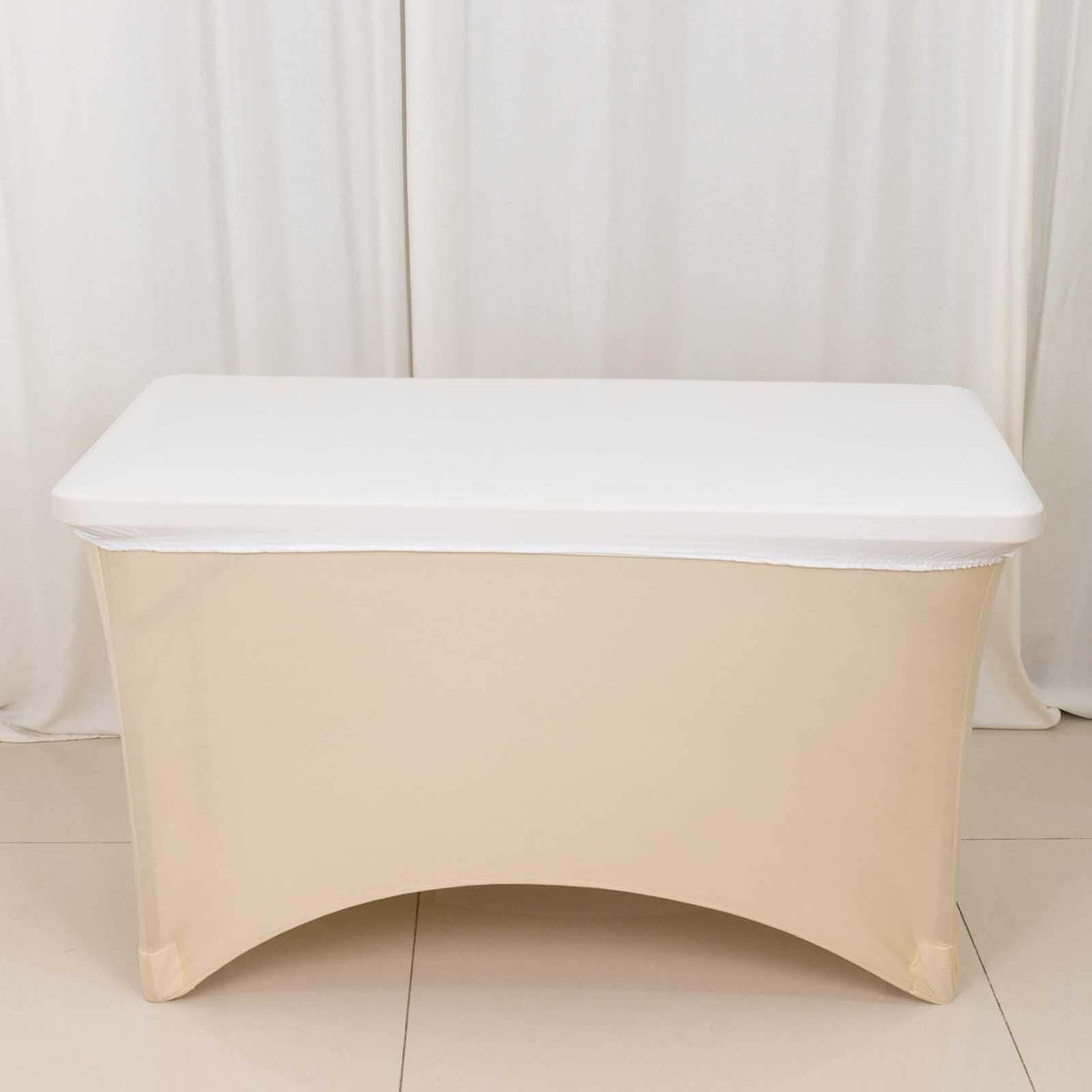 Portable folding table with a white top and cream skirt