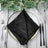 Black textured napkin elegantly placed on a table setting with cutlery and glassware. #whtbkgd