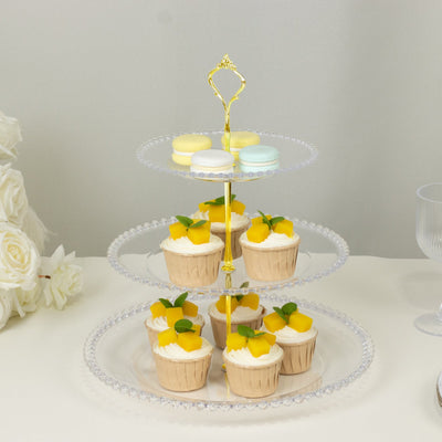 Three-tiered dessert stand with cupcakes and macarons.