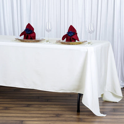 Elegant table setting with red and blue napkins on a white tablecloth.