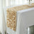 Beige satin table runner with leaf design on a white tablecloth.