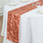 Peach satin table runner on a white tablecloth.