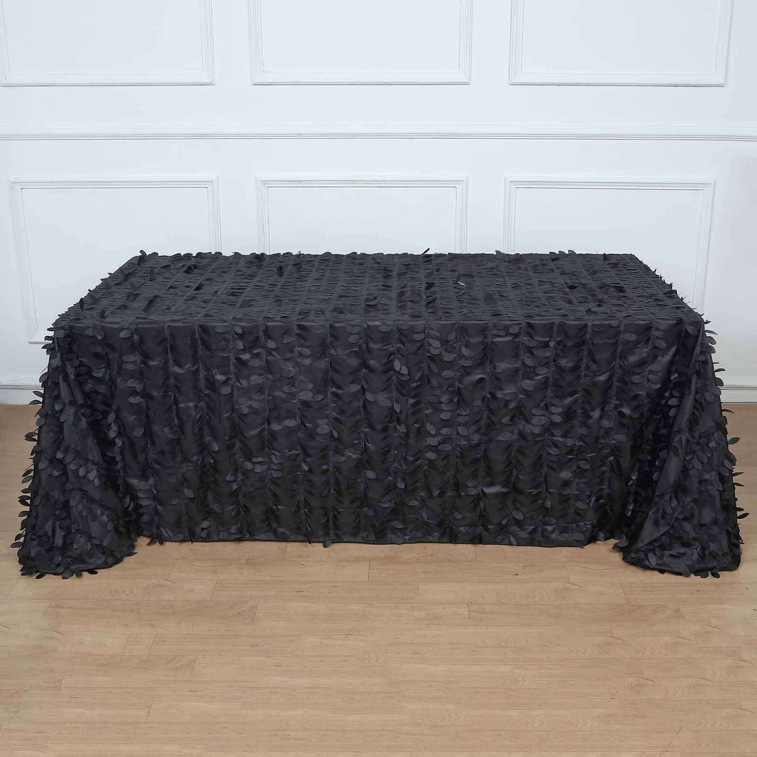 Black textured tablecloth draped over a table in a studio setting.