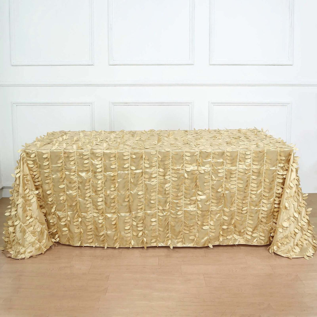 Gold fabric tablecloth with textured embellishments on a plain backdrop.