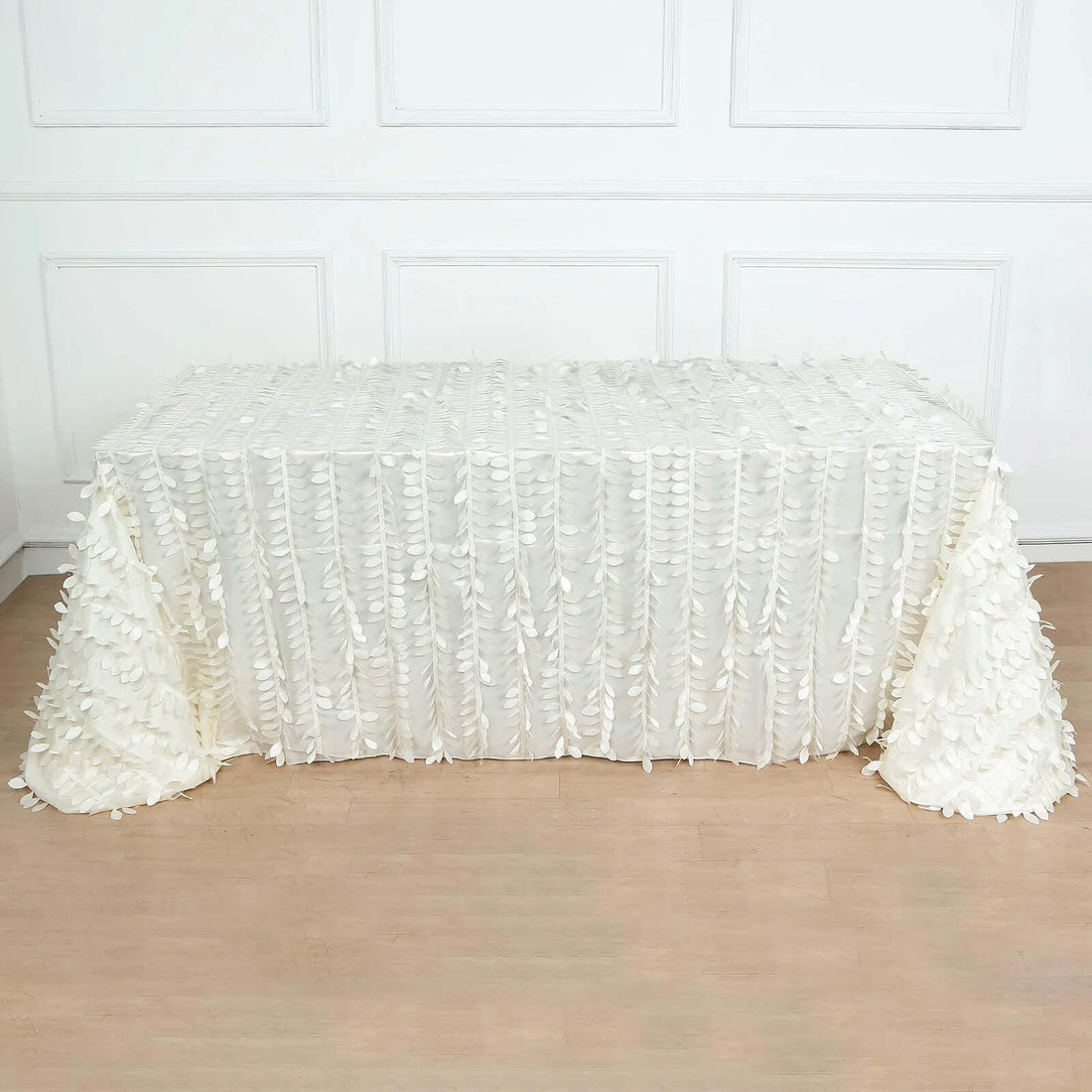 White tablecloth with floral appliqué design draped over a table