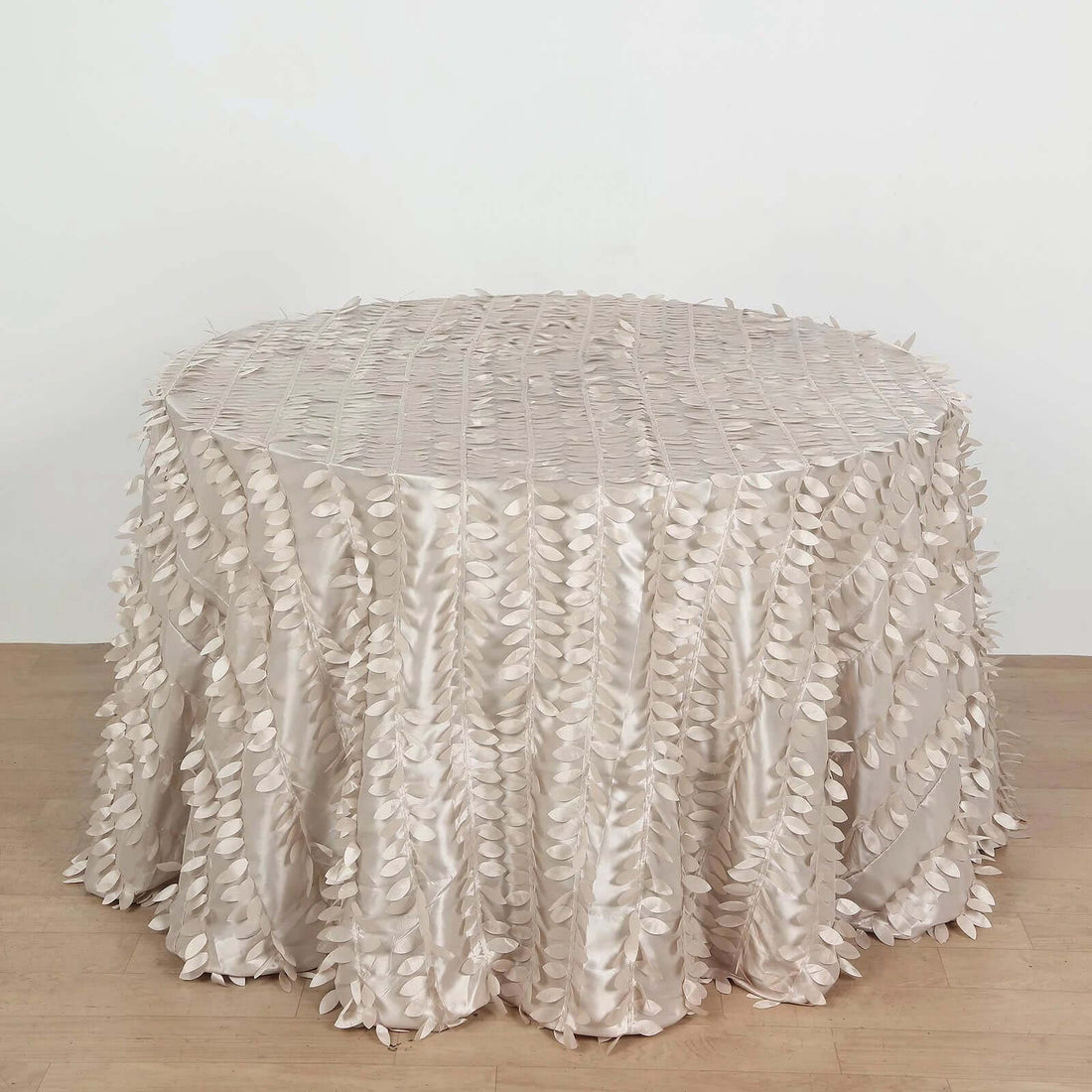 Textured cream tablecloth with leaf appliqués for elegant decor.