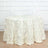 White tablecloth with leaf design draped over a round table