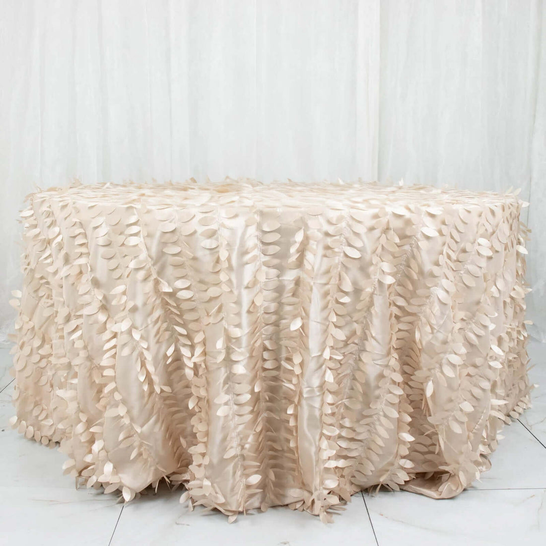 Beige tablecloth with leaf design on a round table.
