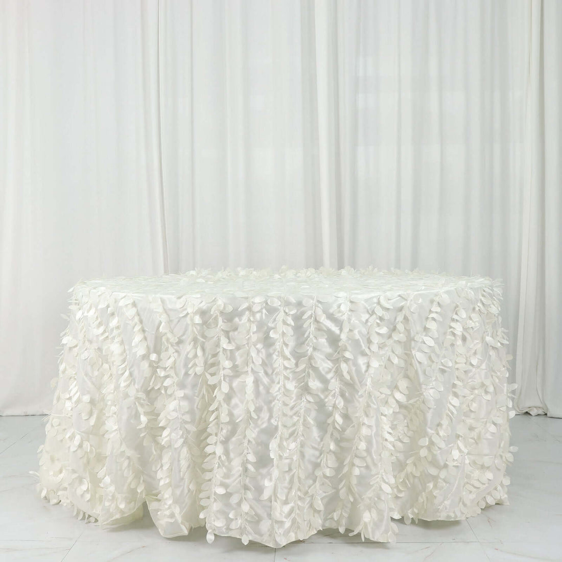 White tablecloth with textured floral design draping elegantly.