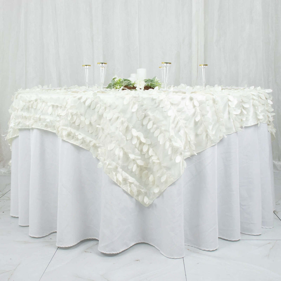 Elegant white tablecloth with textured leaf design, perfect for special occasions.