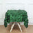Green leaf-patterned tablecloth draped over a wooden table.
