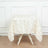 Textured white tablecloth draped over a wooden table in a studio setting.