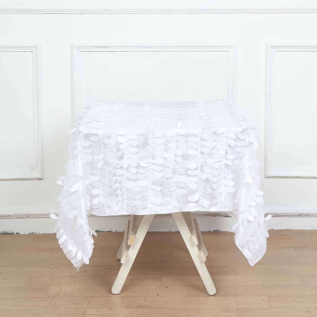 White tablecloth with textured circular accents on a plain backdrop
