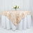 Elegant beige table overlay with floral texture on a white tablecloth.