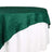 Green tablecloth elegantly draping over a white table. 