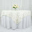 Elegant white tablecloth with floral design and centerpiece of roses.