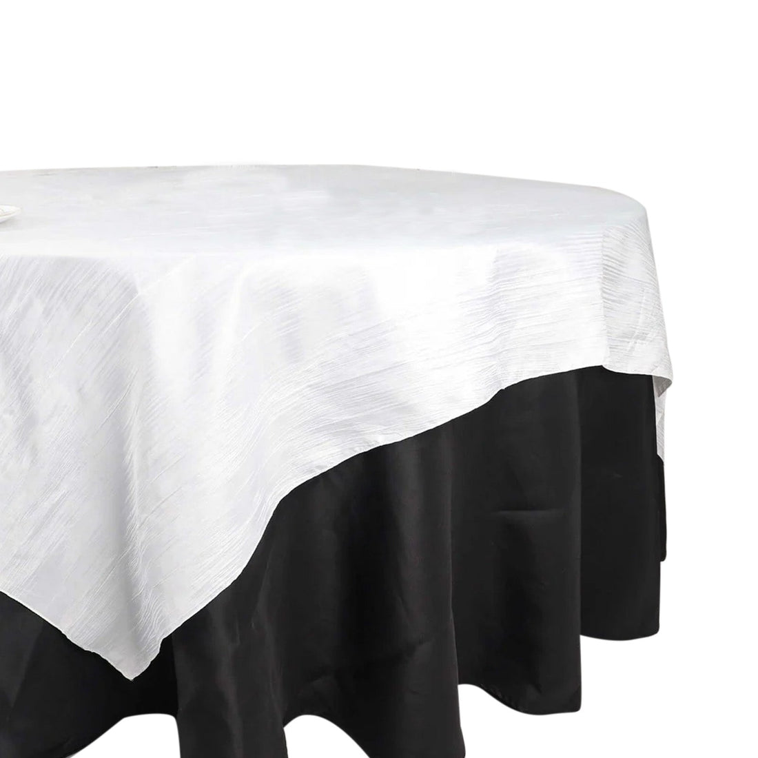 White tablecloth draped over a black tablecloth, showcasing elegant layering.