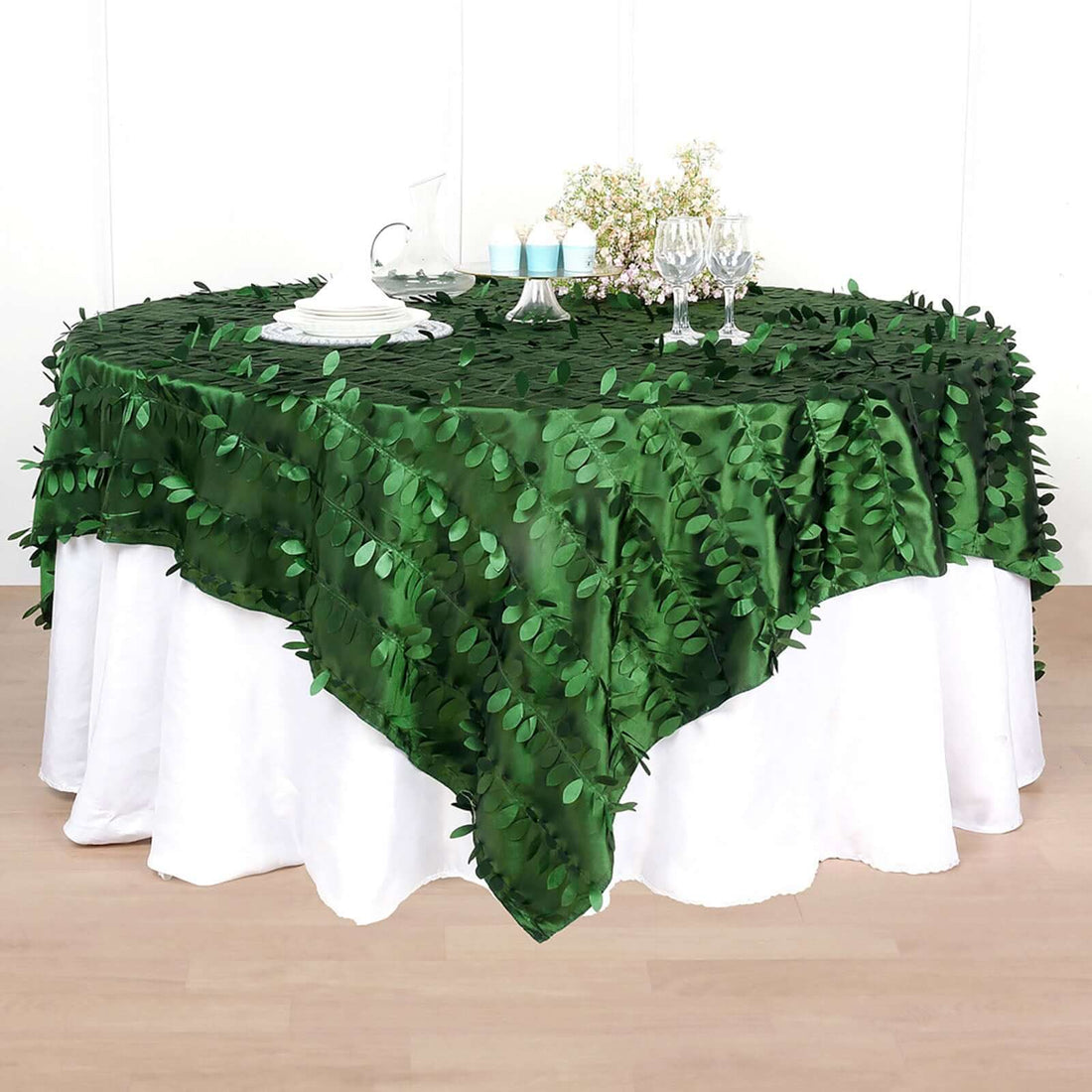 Green leaf-patterned tablecloth draped over a white table.
