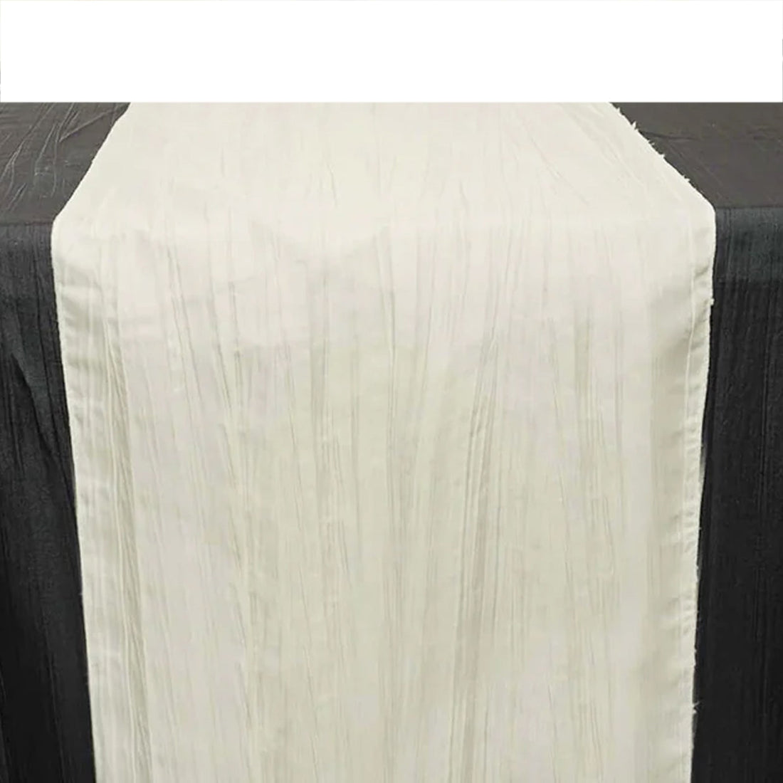 White table runner with textured design on a black table.
