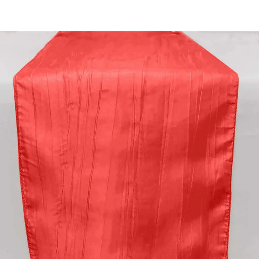 Red table runner with textured stripes, perfect for elegant dining settings.