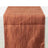 Rust-colored table runner with a textured design on a white background