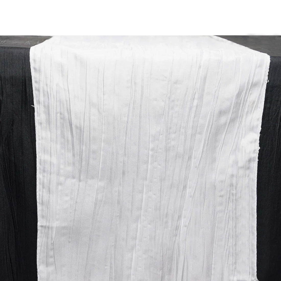 White pleated table runner on a black surface