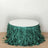 Green fringed table skirt on a round table against a plain background.
