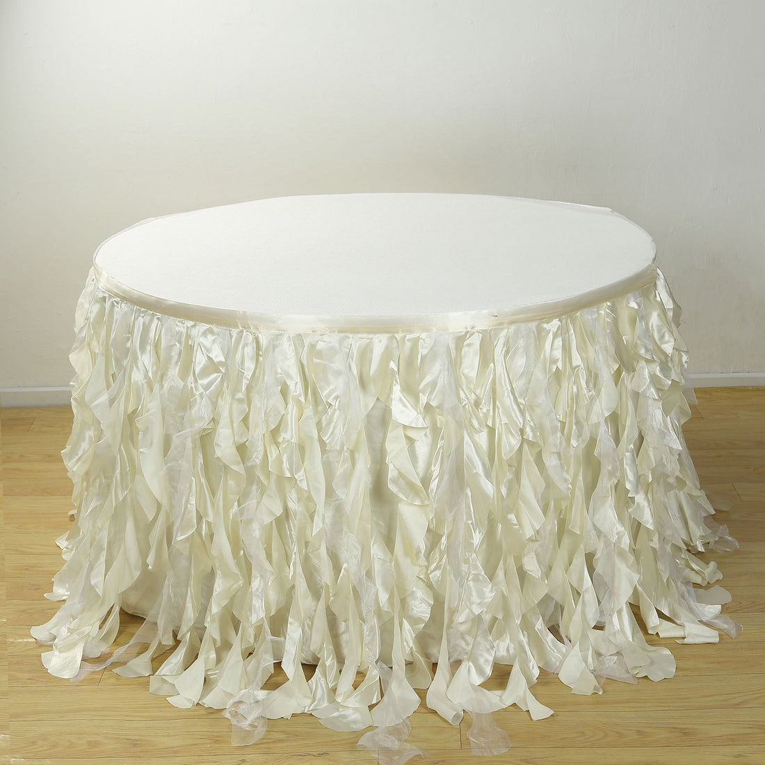 White table with ruffled satin skirt, ideal for events and decorations.