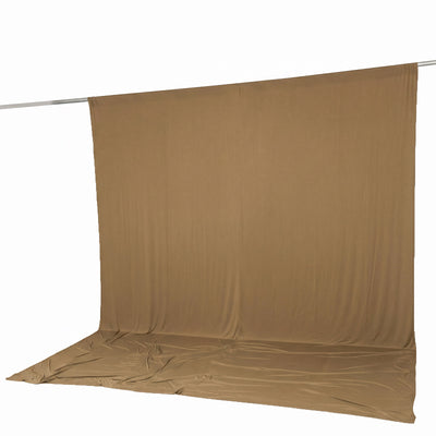 Tan backdrop fabric hanging on a studio background seamless backdrop.