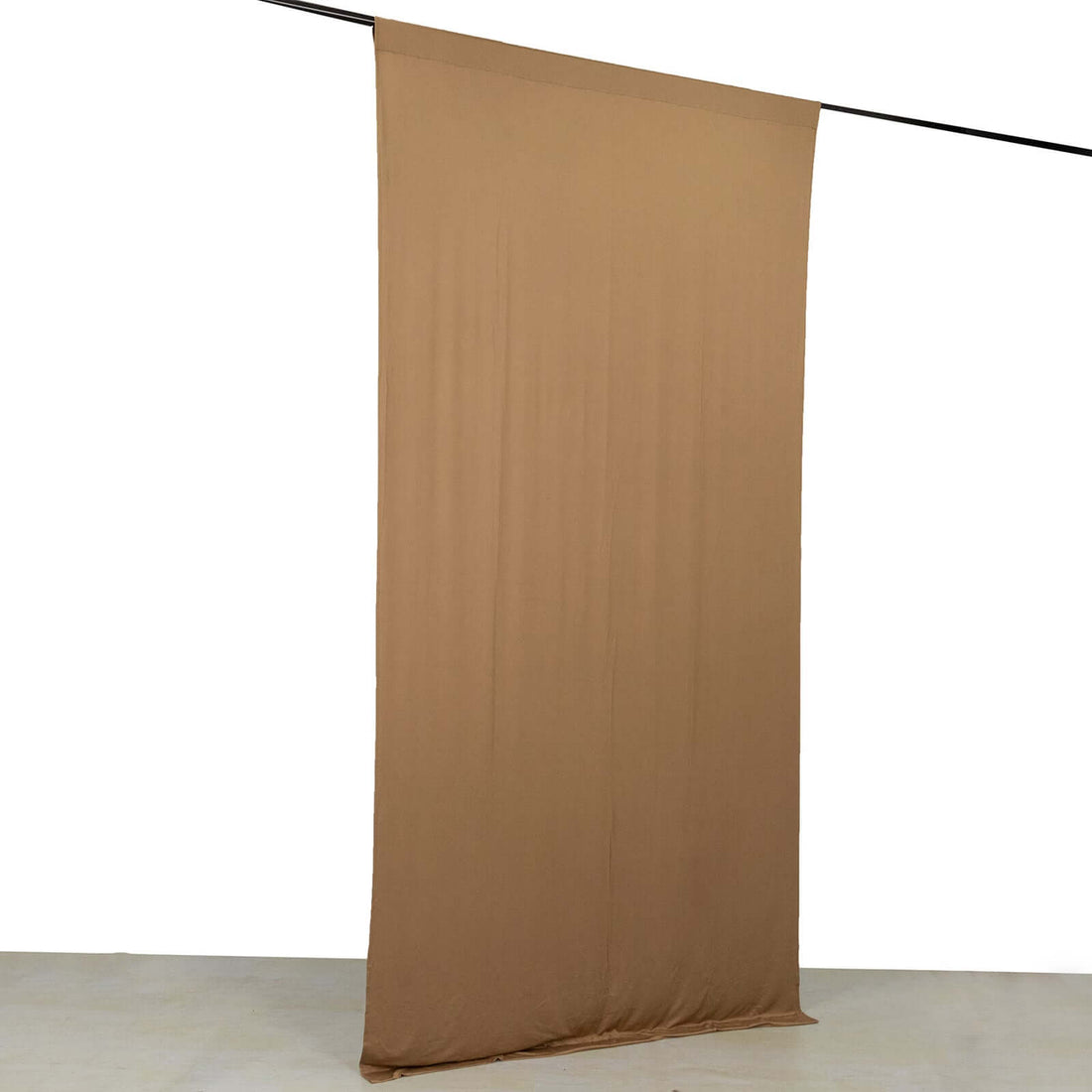 Brown backdrop fabric hanging on a support rod for photography use.