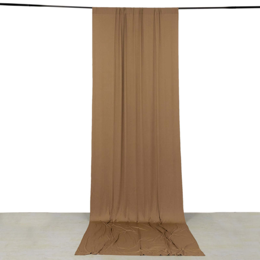 Brown fabric drapery on a white backdrop, showcasing soft texture and flow.