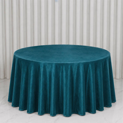 Teal round velvet tablecloth on banquet table with white curtain backdrop