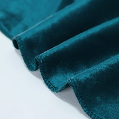 Teal velvet fabric close-up with soft folded texture