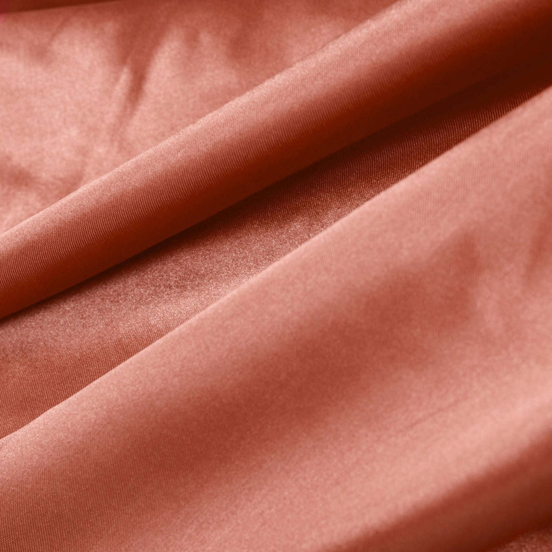 Textured rust-colored fabric with smooth, soft drapes. #whtbkgd