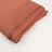 Folded rust-colored fabric on a plain background.
