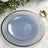 Elegant blue plate with gold rim on marble surface.