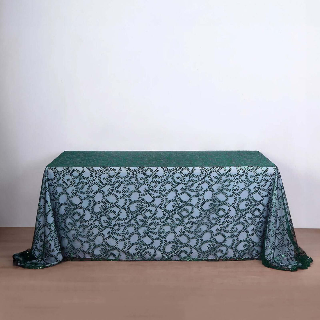 Green patterned tablecloth on a wooden table against a neutral backdrop.